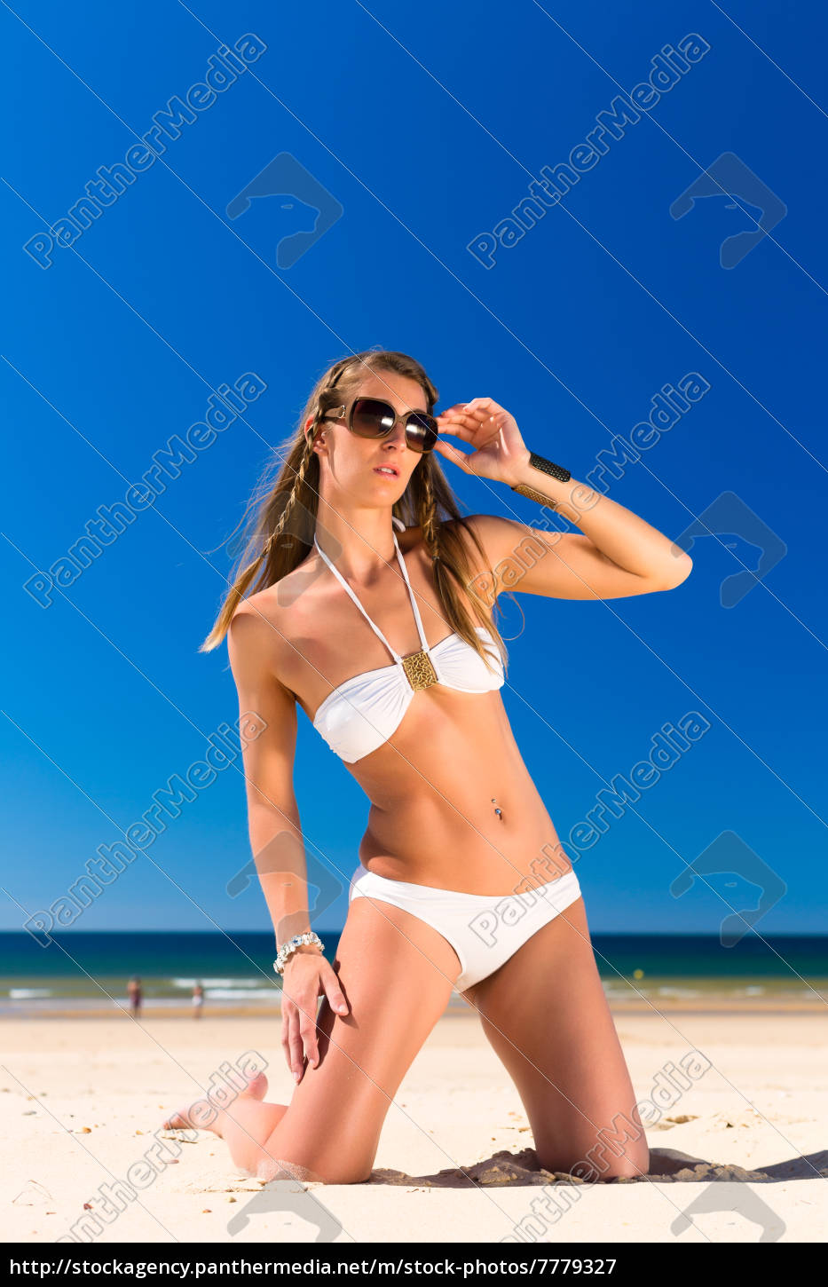 Attraktive Frau Im Bikini Sitzt In Sonne Am Strand Stockfoto