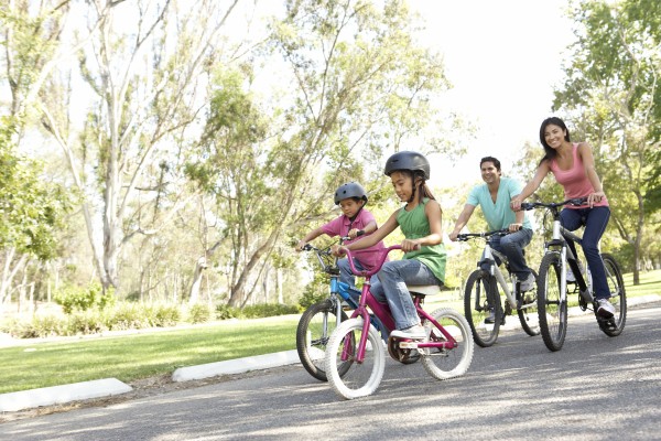 junge familie reitfahrraeder im park