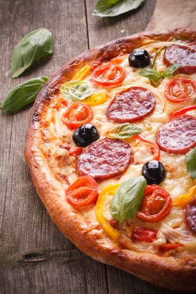 pizza mit salami und gemüse auf altem holzgrund. - Lizenzfreies Bild ...