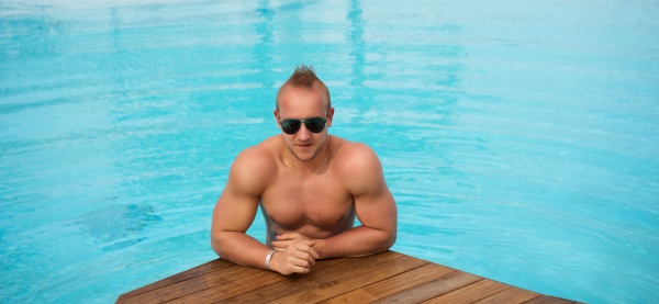 muskuloese mann im swimmingpool aufwirft