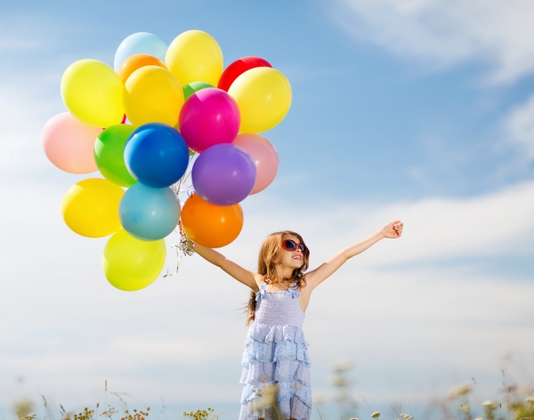 froehliches maedchen mit bunten luftballons