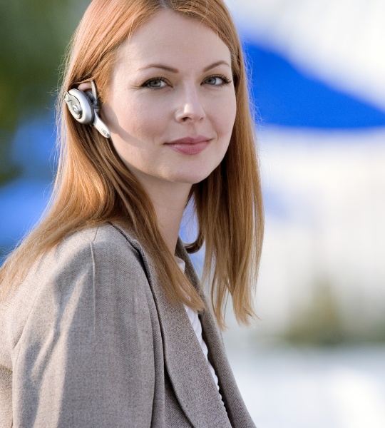 geschaeftsfrau tragen handy freihaendigen vorrichtung laecheln