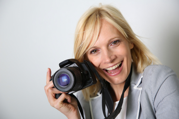 cheerful woman photographer holding camera