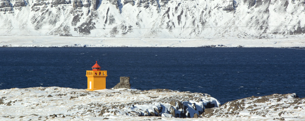 weitschusspanorama eines orangefarbenen leuchtturms island