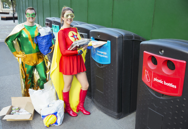 superhero paar recycling auf stadtbuergersteig