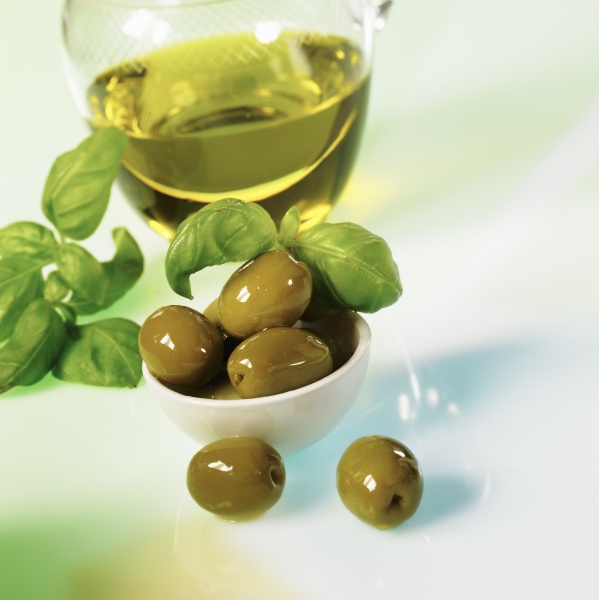 gruene oliven mit olivenoel und basilikum