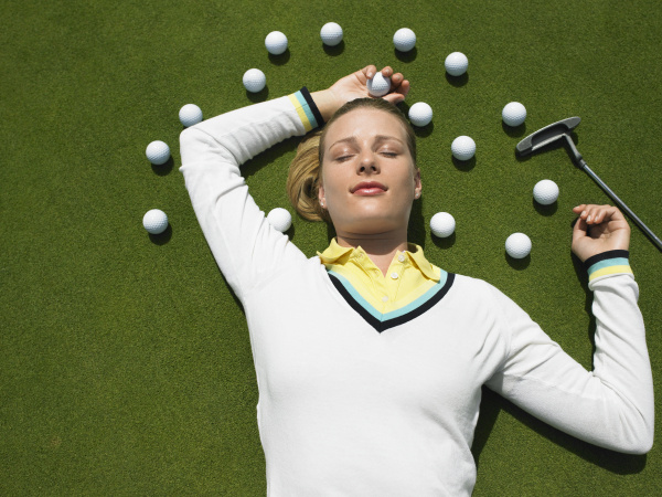 frau liegt auf dem putting green