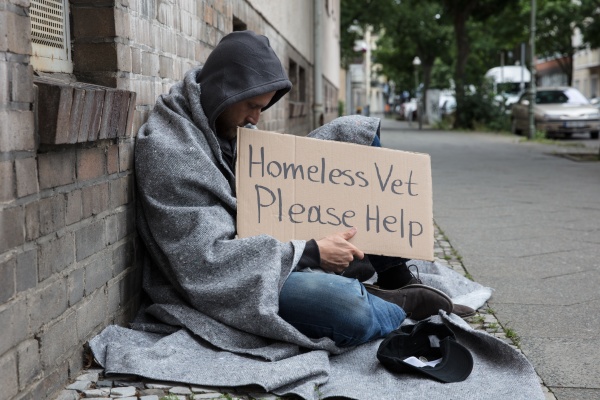 maennliches obdachloses sitzen auf einer strasse