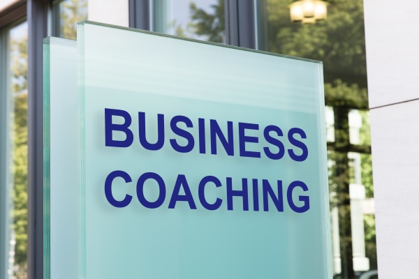 business coaching schild auf glastafel vor