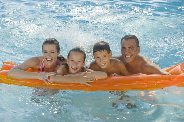 familie die auf floss im swimmingpool