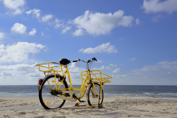 gelbes fahrrad steht am strand