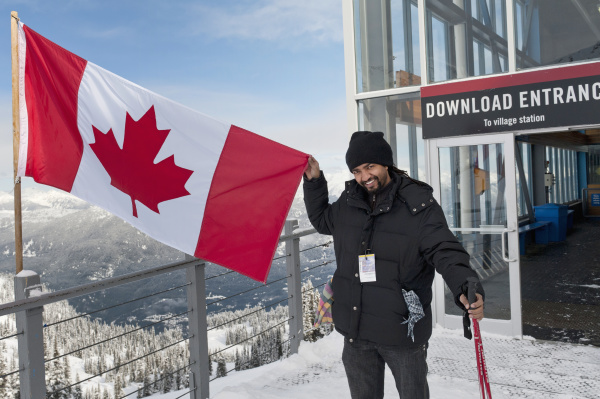 ein skifahrer haelt eine kanadische flagge