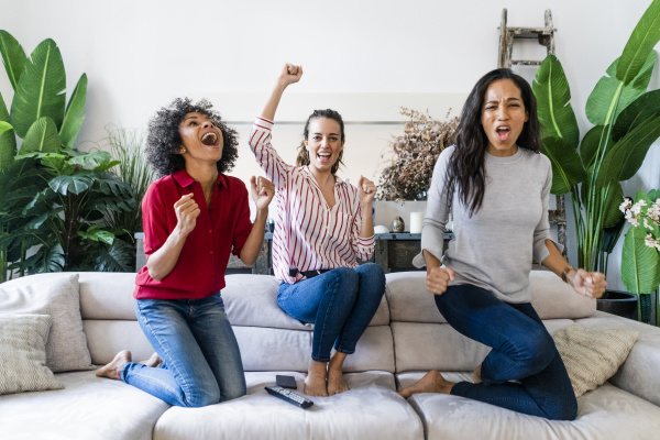 drei aufgeregte frauen auf der couch