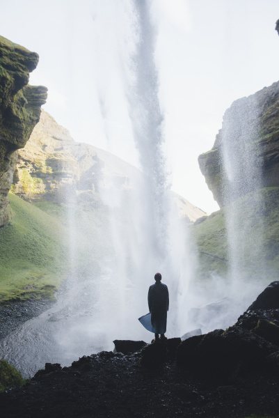 silhouette des menschen hinter kvernufoss wasserfall