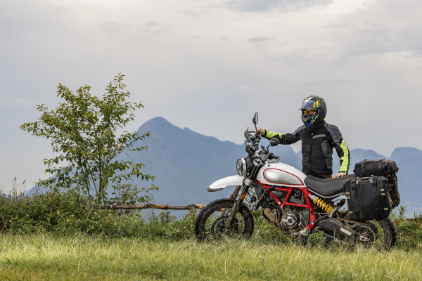 biker posiert neben offroad motorrad berge