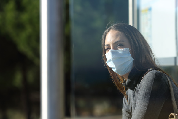 frau mit maske wartet in einer