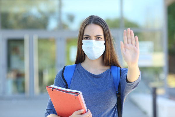 student mit einer maske gestikulieren stopp