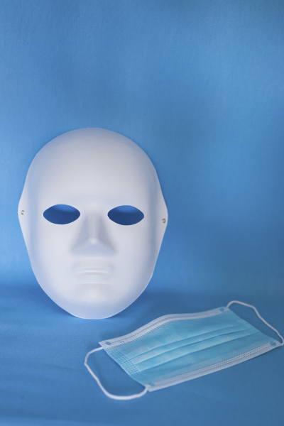 studioaufnahme von theatermaske und schuetzender gesichtsmaske