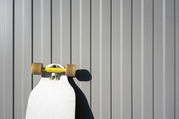 skateboard an sonnigem tag gegen metallwand