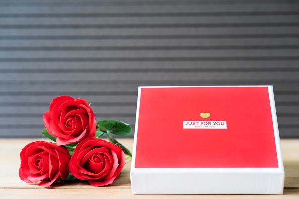 rote rosen und herzfoermige kiste auf