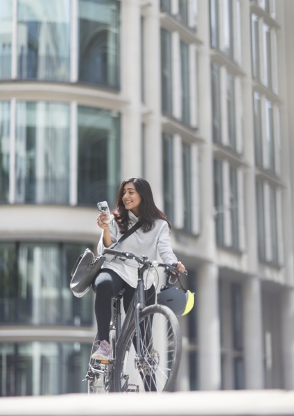 frau mit smartphone auf fahrrad in