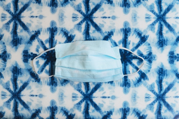 gesichtsmaske auf gemustertem blauem hintergrund