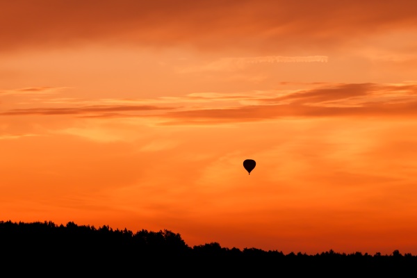 heissluftballon fliegt am sonnenuntergangshimmel