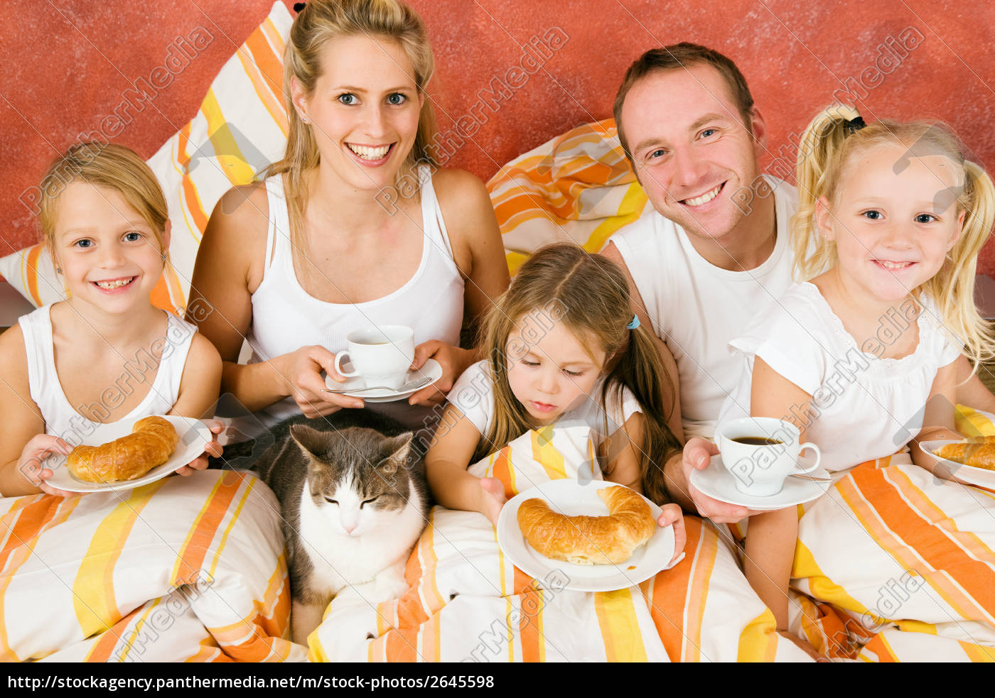 Familie mit Katze im Bett beim Frühstück - Stockfoto ...