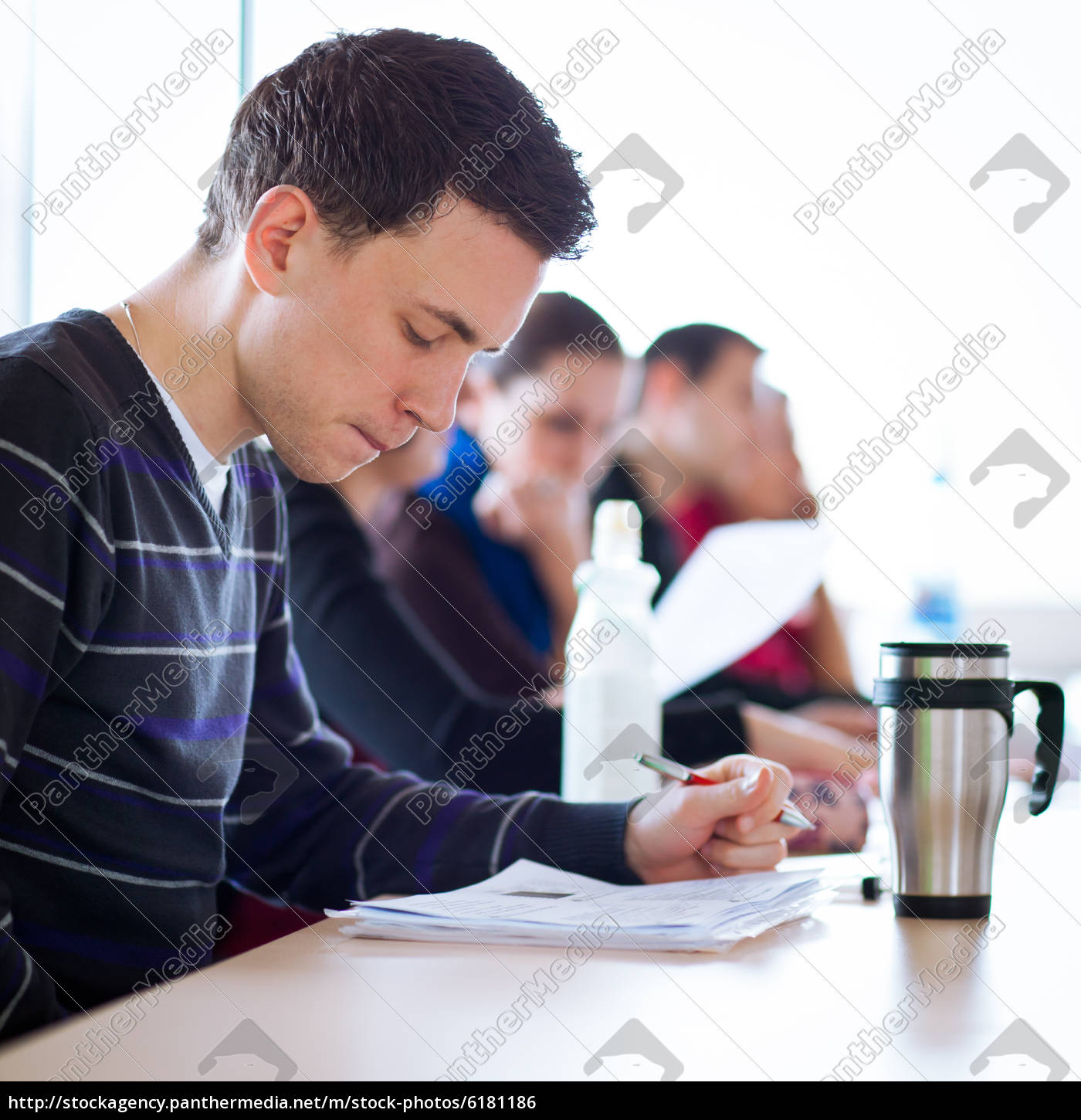 Young Male College Student Sitting In A Classroom Stock Photo
