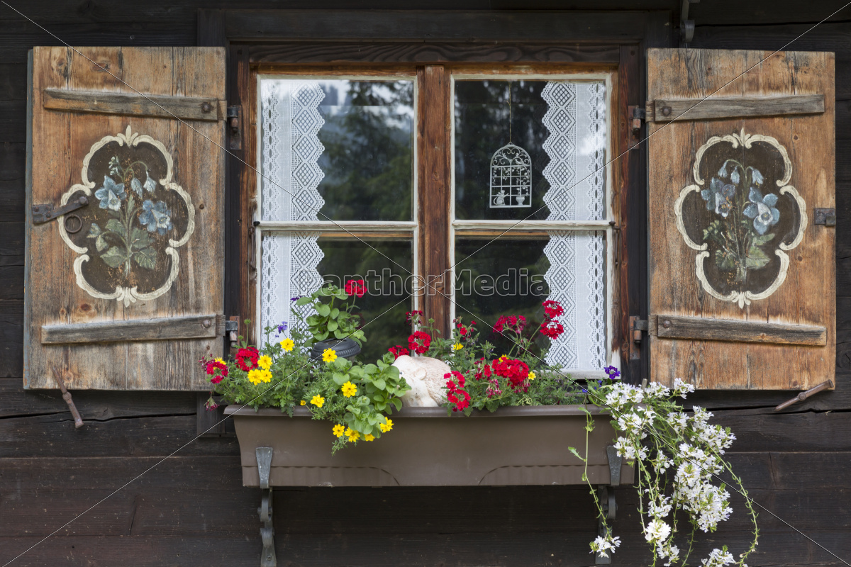 Fenster einer Almhütte mit Blumenkasten Stock Photo