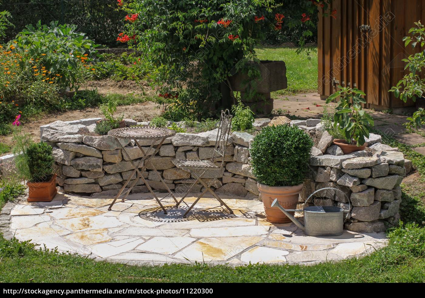 Sitzplatz im Garten mit Kräuterbeet Lizenzfreies Foto