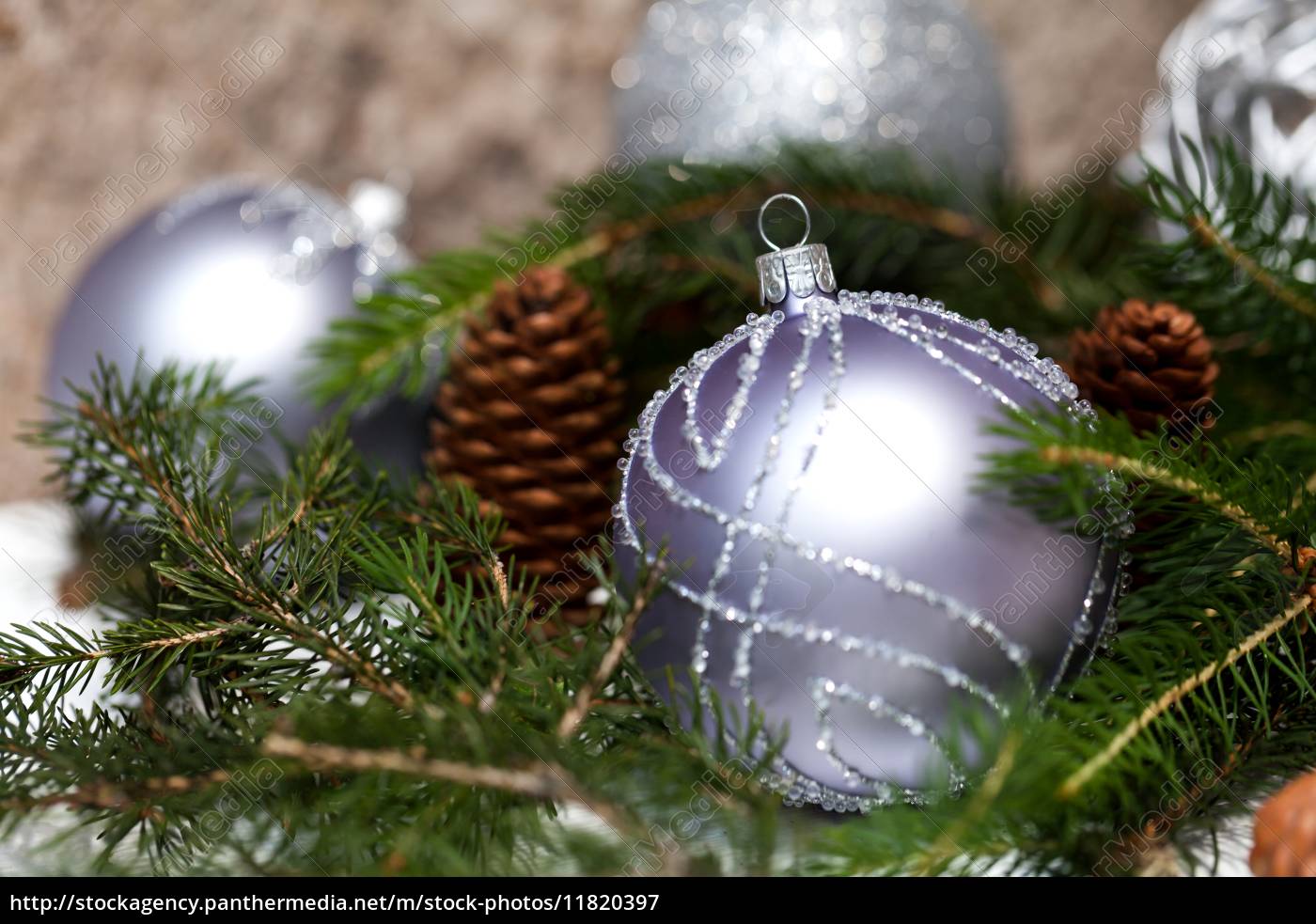 Silberne Christbaumkugeln in grünen Tannenzweigen mit Lizenzfreies