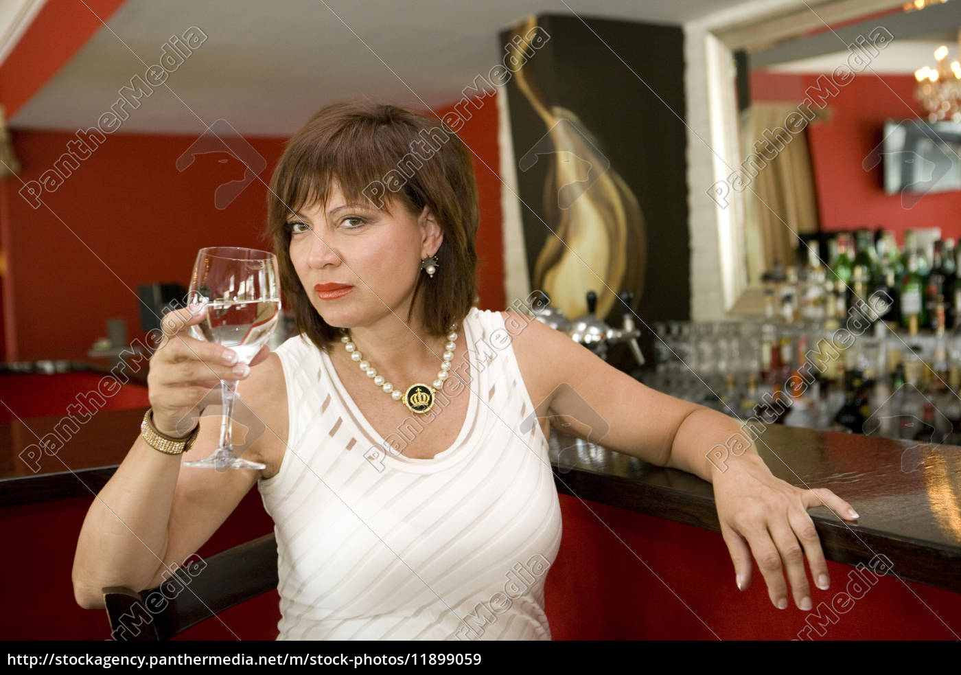 Frau In Weissen Kleid Sitzt An Der Theke Einer Bar Stockfoto Bildagentur Panthermedia