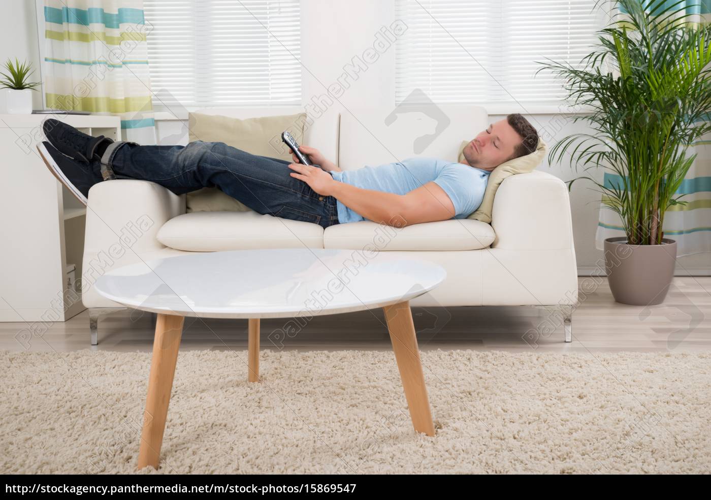 Mann Mit Fernsteuerung Auf Sofa Zu Hause Stockfoto 15869547