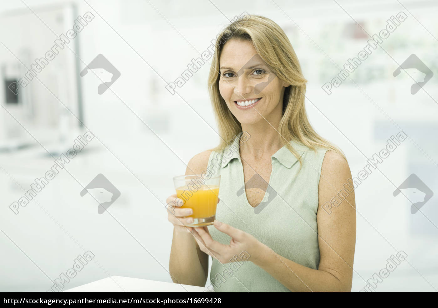 Frau Die Ein Glas Orangensaft Hochhält In Die Kamera Lizenzfreies