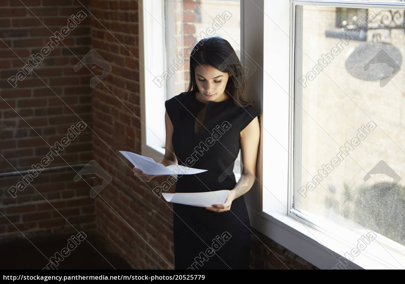 Geschäftsfrau Liest Dokument Stehend Im Bürofenster Lizenzfreies Bild 20525779 