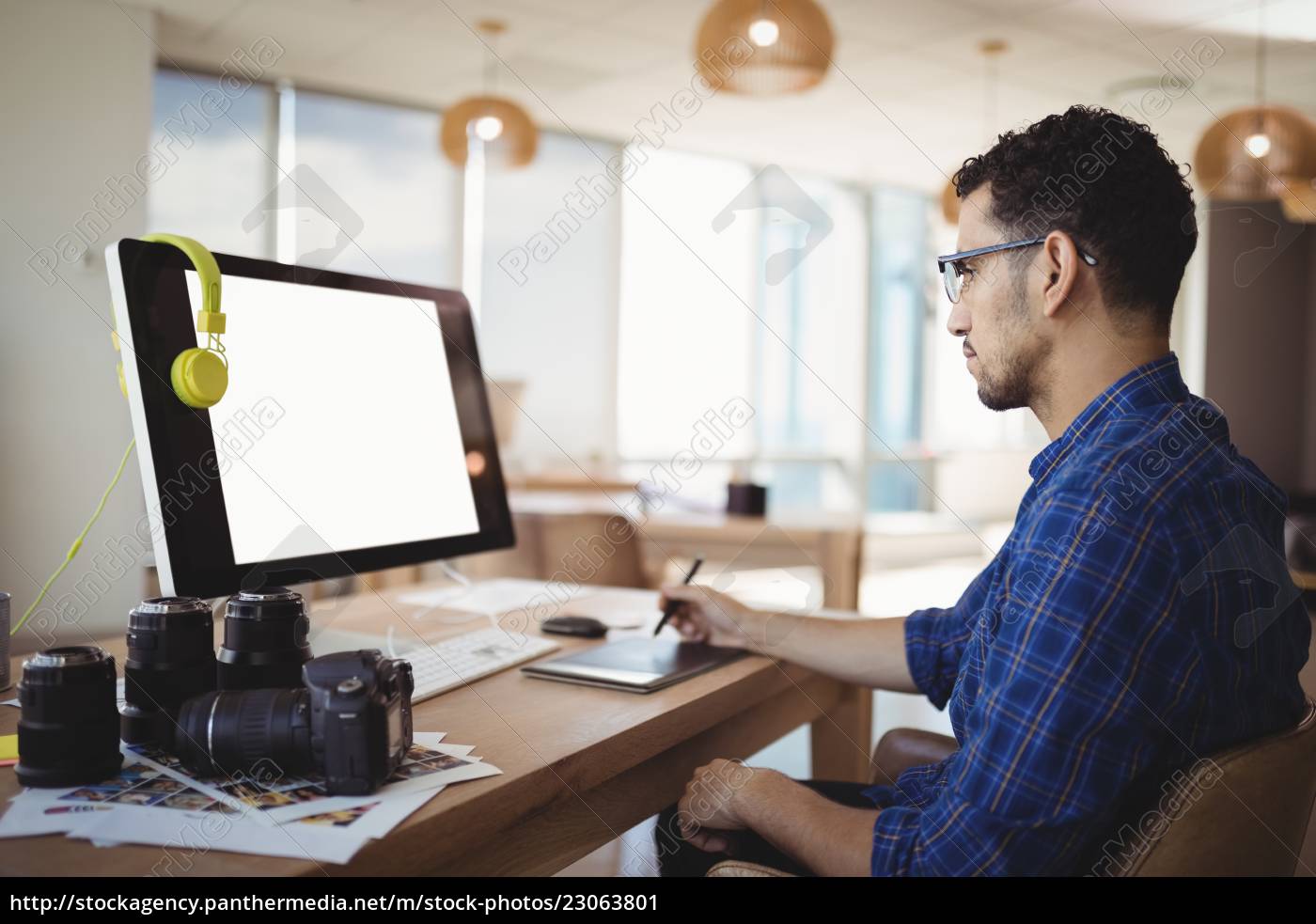 Attentive Graphic Designer Using Graphic Tablet At Desk