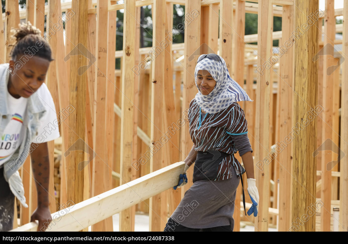 volunteers-carrying-lumber-at-construction-site-stock-photo