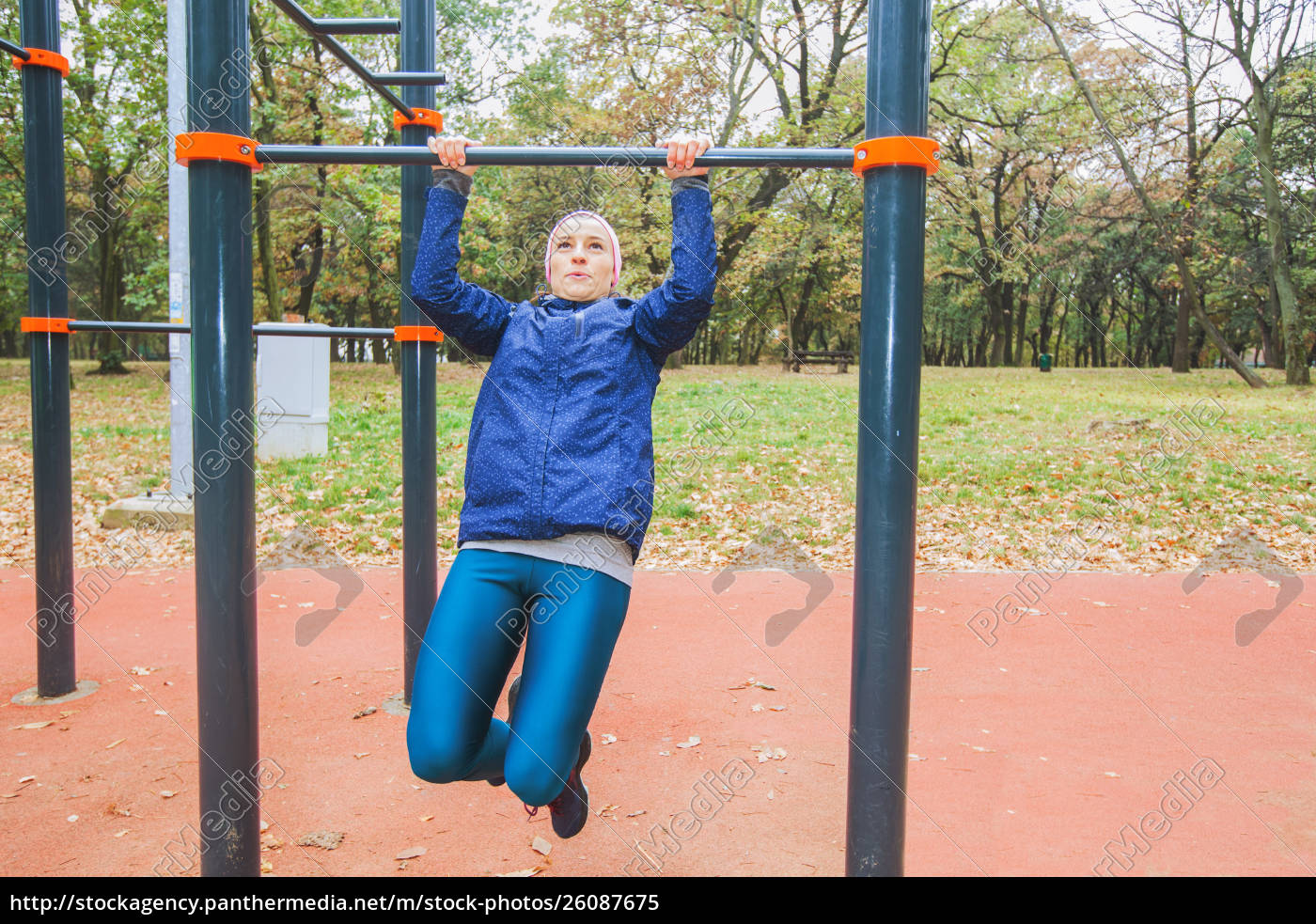 sporty-girl-doing-pull-ups-exercise-at-outdoor-gym-lizenzfreies-bild