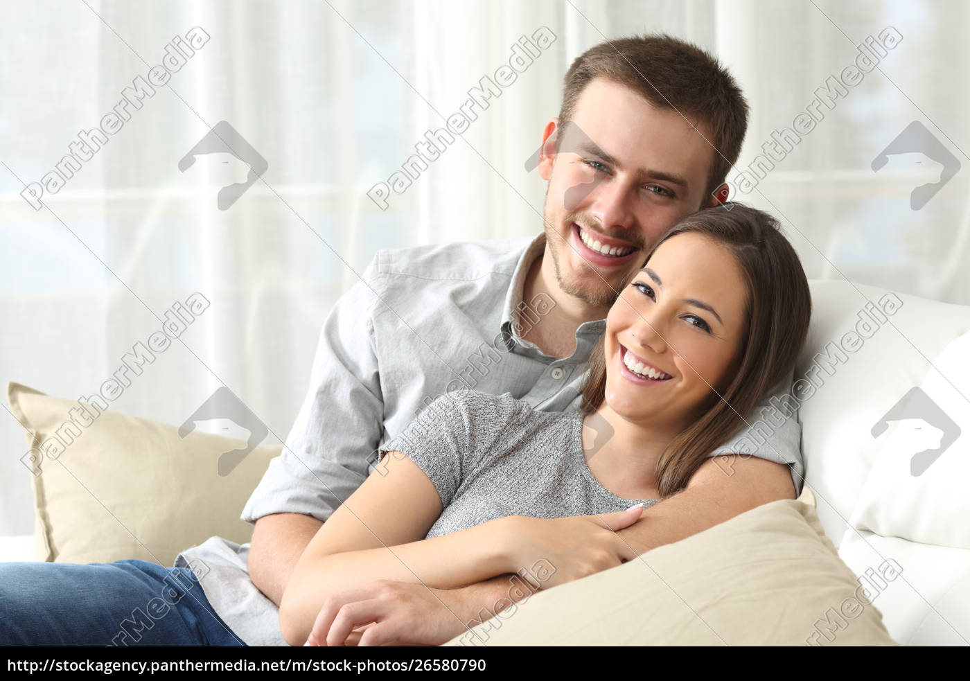 Gluckliches Paar Das Zu Hause Zur Kamera Schaut Stock Photo Bildagentur Panthermedia