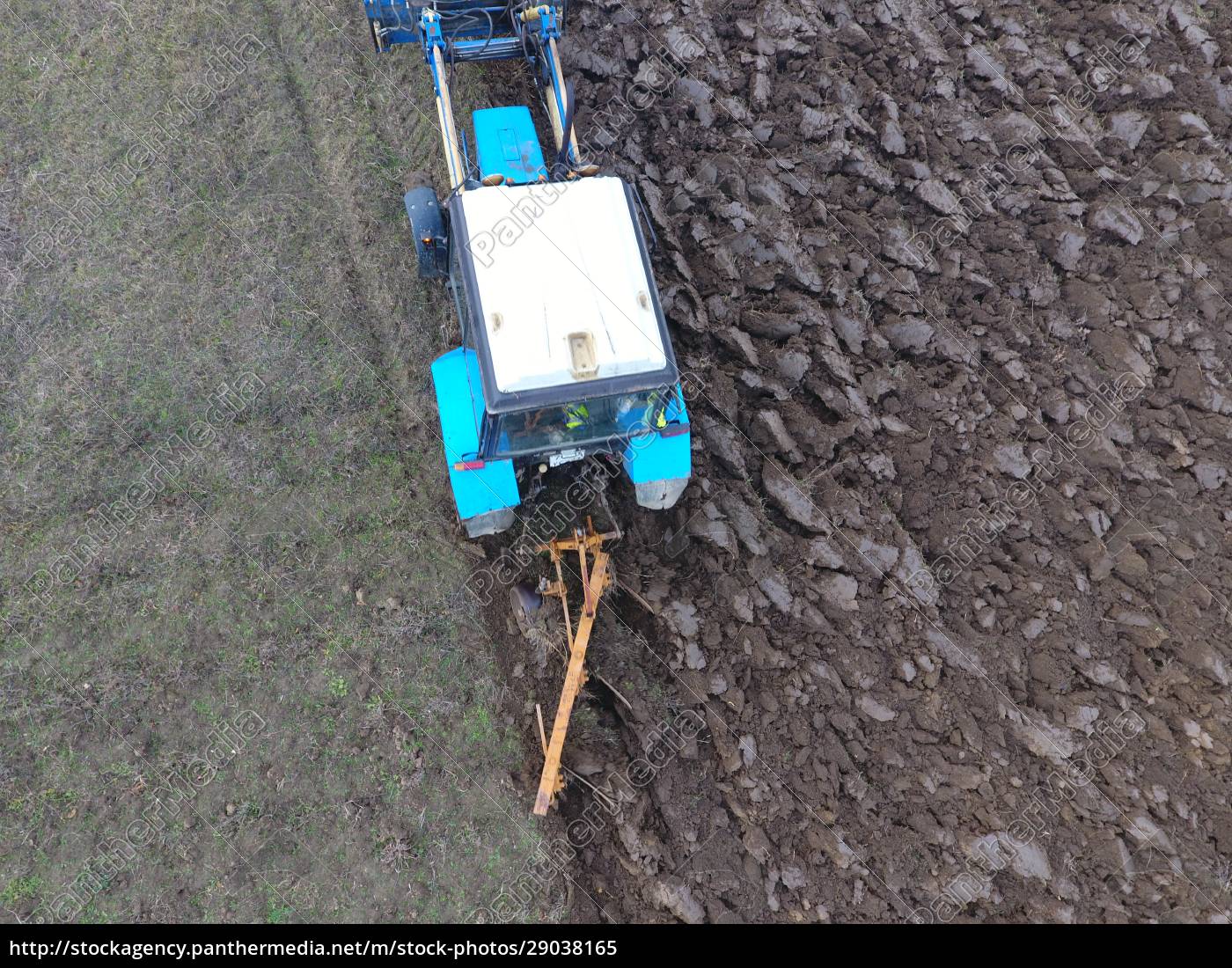 Traktor pflüget den Garten. Pflügen des Bodens im