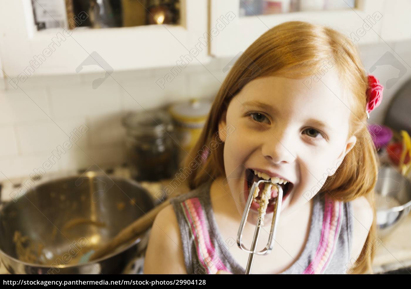 Girl Licking Mixture From Whisk In Kitchen Lizenzfreies Foto